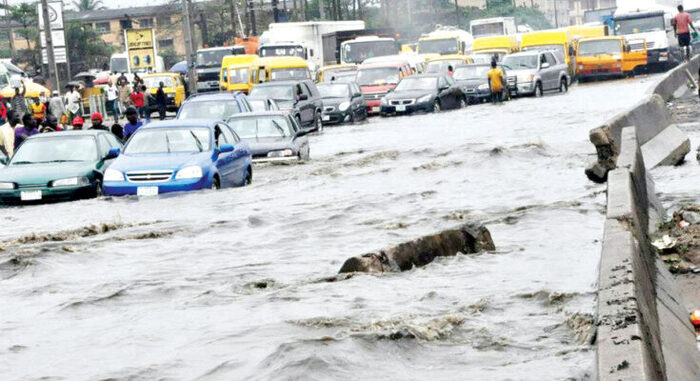 Residents wade through floodwaters during Lagos flooding on a submerged street in Festac.
