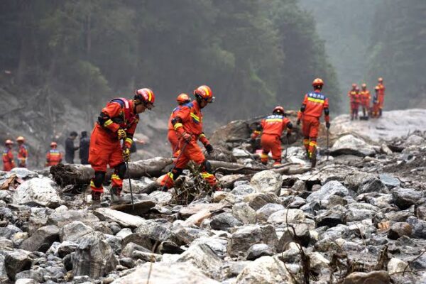 Mourners gather during the burial and cremation of victims killed by devastating floods in Nepal