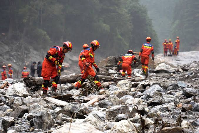 Mourners gather during the burial and cremation of victims killed by devastating floods in Nepal